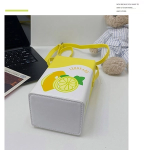 Detail view of square lemon milk carton bag with yellow print and skinny strap
