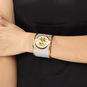 Macro shot of gold sun embossed pattern on wide stainless steel textured bangle
