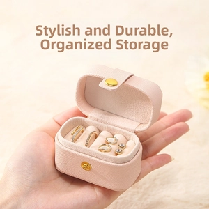 Close-up of pink portable PU leather jewelry box showing ring slots and velvet lining