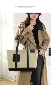 Detail der khakifarbenen Canvas-Tasche mit schwarzen Riemen und Lederlogo auf der Tasche