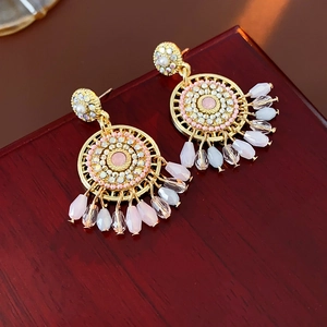 Vintage golden dreamcatcher earrings with pink pearls and rhinestones on wood