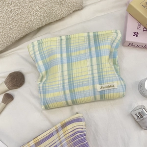 Detail of yellow and blue plaid makeup bag with woven texture and Sozakka label