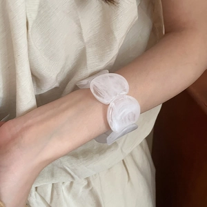 Close-up of white marble acrylic linked bracelet worn on wrist with elegant minimalist style