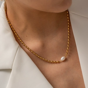 Gold oval bead chain necklace with a single natural freshwater pearl pendant on a model
