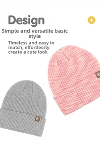 Detalle de gorros de punto acanalado en gris y rosa con un parche decorativo de cuero marrón