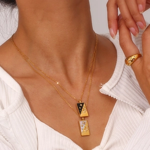 Detail of 18K gold tarot necklaces and star ring worn by a model in a lifestyle setting