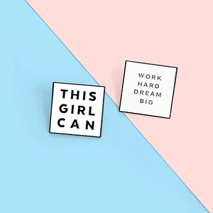 Detail of square enamel pins with 'THIS GIRL CAN' and 'WORK HARD DREAM BIG' quotes