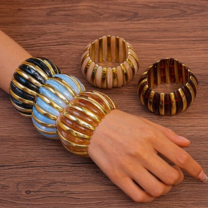 Detailed view of wide acrylic resin bracelets with marble texture and gold metal accents