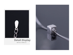 Detail display of silver cube pendant with brushed metal texture and droplet extension chain