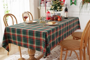 Close-up of red and green plaid festive tablecloth with soft texture and tassels