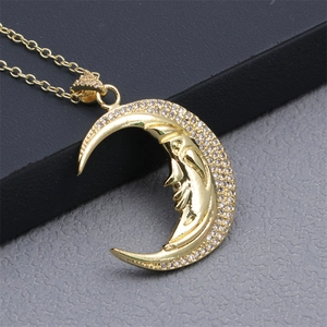 Macro shot of gold crescent moon face pendant necklace with micro-pave zircon crystals