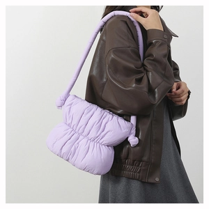 Close-up of a lilac padded puffer bucket bag with soft pleated nylon texture and shoulder strap