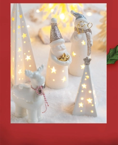 Detailed view of glowing ceramic Christmas tree with star cutouts and festive warm LED light