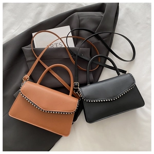Detail shot of vintage PU leather square handbags with stylish metal stud trim and top handles