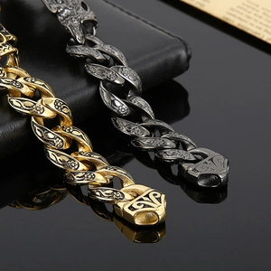 Detail of vintage gold and black gunmetal Cuban chains with intricate engraved patterns