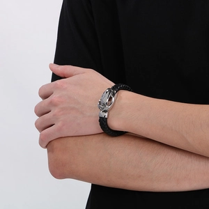 Detail of a men's woven leather bracelet with a unique lion head punk buckle on wrist