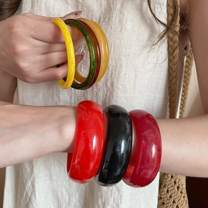 Detailed view of colorful resin bangles featuring marble patterns and retro design style