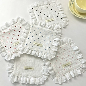 Close-up of quilted heart-patterned placemats with delicate ruffled lace edges in multiple colors