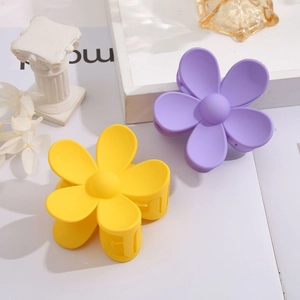 Detail of matte flower hair claws in yellow and purple set on decorative props
