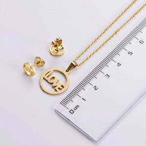 Detail view of gold titanium steel love jewelry set with size measurement scale
