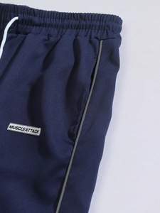 Detail of navy blue woven joggers with white drawstring and branded pocket tag
