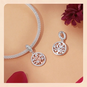 Detail of rose gold tree of life charm with zircon on a silver mesh bracelet