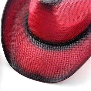 Close-up of red and black ombre western cowboy hat showing fine woven texture and gradient