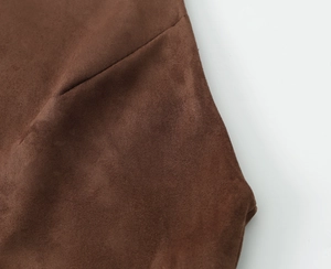 Détail de la texture en daim marron foncé sur le haut à manches longues minimaliste