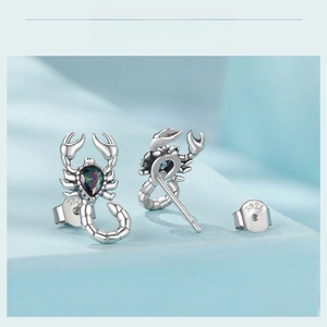 Macro detail of S925 sterling silver stamp on scorpion stud earrings with rainbow gemstone