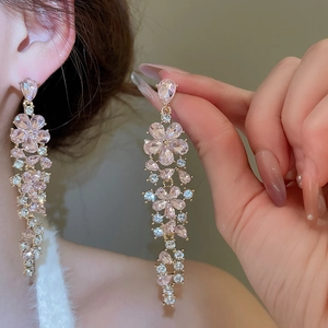 Detail of pink crystal flower tassel earrings worn by model with sparkling rhinestones