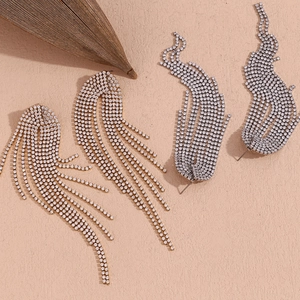 Detailed view of long gold and silver tassel earrings with sparkling rhinestones