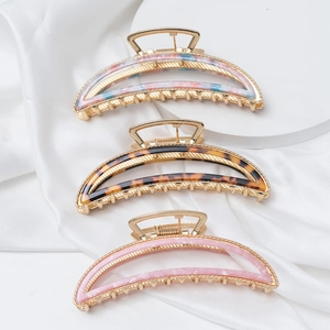 Three elegant crescent metal shark hair clips in tortoiseshell and pink on silk