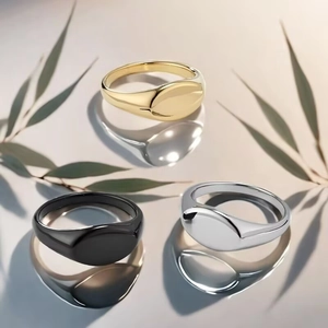 Detailed view of oval polished titanium rings in gold, black, and silver finishes