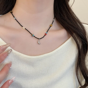 Close-up of beaded necklace with colorful natural stones and silver crescent pendant