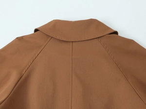 Detailed view of the lapel collar and shoulder stitching on a brown woven jacket