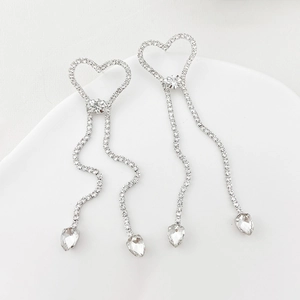Boucles d'oreilles cœur argentées avec pompons, strass étincelants et pendentifs en cristal
