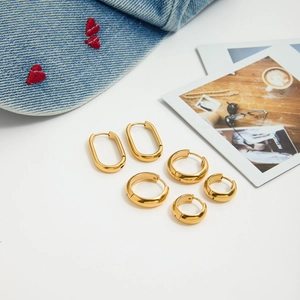 Détail du lot de boucles d'oreilles créoles et en U en acier doré 18 carats sur fond blanc