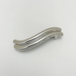 Close-up of wave-shaped silver alloy hair clip with polished metallic finish and punk style