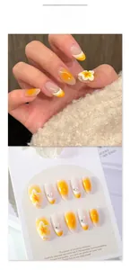 Detail of 3D plumeria flower accents and orange gradient on almond press-on nails