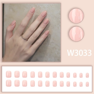 Detail of short square-oval press-on nails in glossy nude pink with model hand display