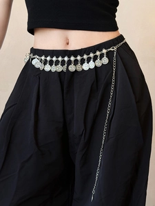Détail de la chaîne de taille en métal argenté avec pendentifs pièces et gland sur mannequin