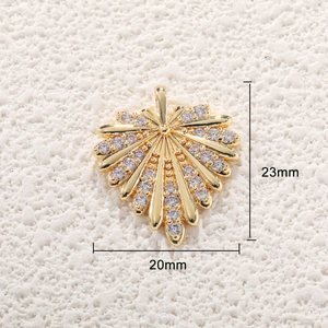 Macro shot of gold leaf pendant with rhinestones and size details 23mm by 20mm