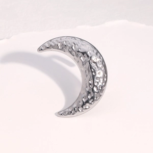 Detailed close-up of crescent moon ring featuring hammered texture and silver finish