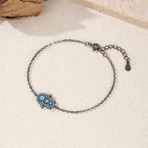 S925 sterling silver bracelet featuring a blue Hamsa hand charm on a natural stone background