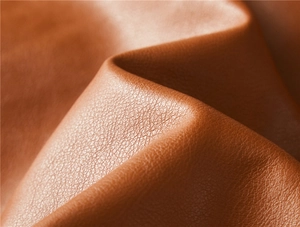 Detailed close-up showing the brown lychee-patterned leather texture and premium grain finish