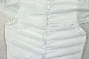 Close-up of white mesh fabric texture with center ruched detailing on a sleek dress