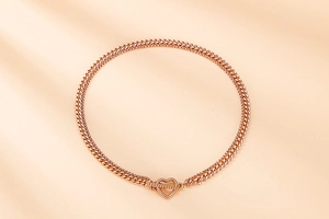 Detailed view of golden double-layer chain necklace featuring a heart OT toggle clasp