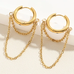 Close-up of 18K gold plated asymmetric hoop earrings with tassel chains on stone