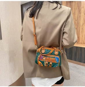 Detail of multi-color patchwork leather bag with colorful rivets and metal chain charm