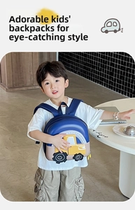 Close-up of kids hard shell backpack featuring 3D yellow truck design and wide straps